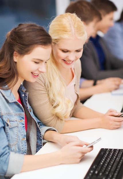 educazione, tecnologia e concetto di internet - gruppo di studenti sorridenti con monitor di computer e smartphone