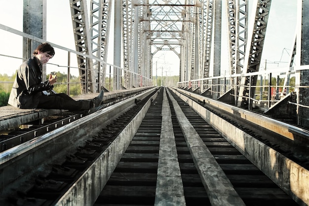 Effetto graffio su foto uomini con chitarra su una ferrovia