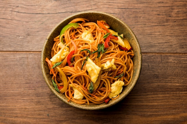 Egg Schezwan o hakka noodles, popolare cibo indo-cinese servito in una ciotola con le bacchette