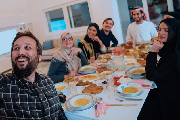 Eid Mubarak Famiglia musulmana che cena Iftar scatta foto con lo smartphone mentre mangia cibo tradizionale durante il mese di festa del Ramadan a casa. La famiglia islamica islamica che mangia e beve halal.