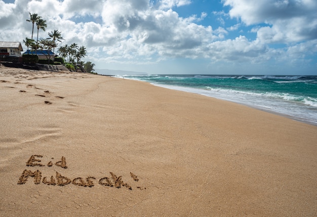 Eid Mubarak scritto nella sabbia su una spiaggia alle Hawaii