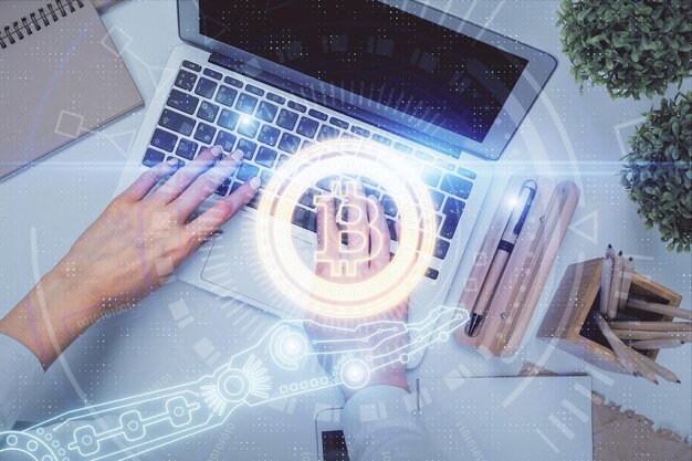 Eksposur ganda tangan wanita yang sedang mengerjakan komputer dan gambar hologram tema blockchain Tampilan Atas konsep mata uang kripto bitcoin