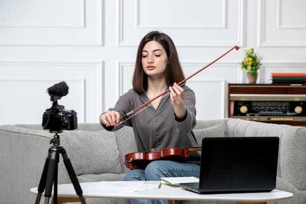 Elearning giovane bella ragazza carina a distanza a casa dando lezioni di violino a suonare