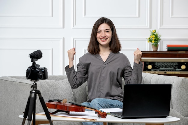 Elearning giovane bella ragazza carina a distanza a casa dando lezioni di violino molto fiducioso