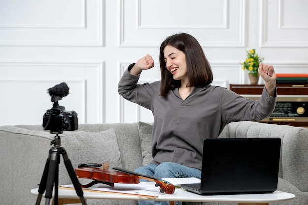 Elearning giovane bella ragazza carina a distanza a casa dando lezioni di violino stretching