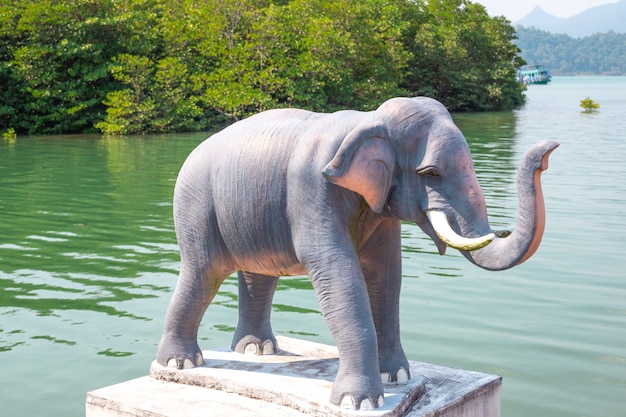 Elefante su un piedistallo sulla sponda di un fiume in Asia