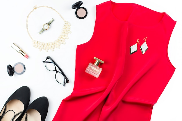 Elegante abito rosso da donna, gioielli, trucchi e tacchi neri. Disteso
