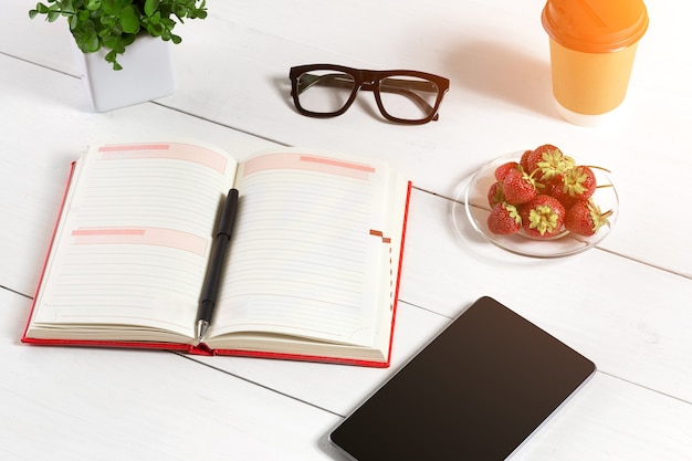 Elegante ambiente di lavoro minimalista con tablet e notebook e occhiali in stile piatto. Sfondo bianco. Vista dall'alto. Copia spazio. bagliore di sole