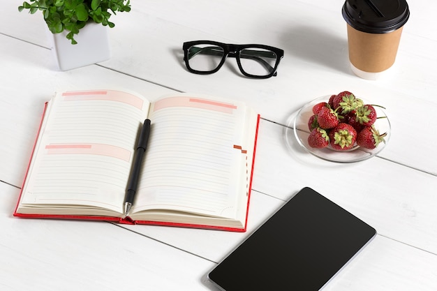 Elegante ambiente di lavoro minimalista con tablet e notebook e occhiali in stile piatto. Sfondo bianco. Vista dall'alto. Copia spazio