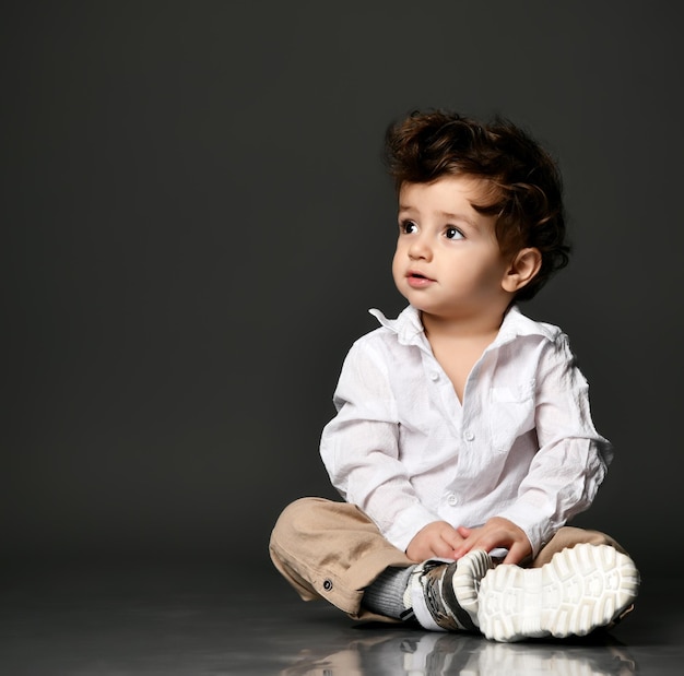 Elegante bambino alla moda Modello di bambino bambino che indossa abbigliamento casual Ritratto isolato colpo isolato su sfondo grigio studio Moda e stile Vestito alla moda per la pubblicità del bambino