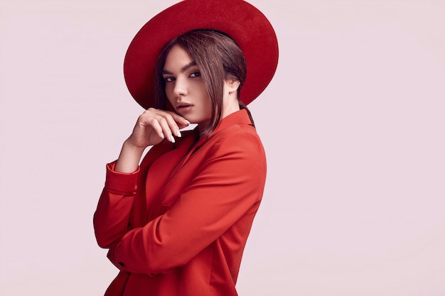 Elegante bella donna in un vestito alla moda rosso e cappello largo