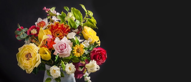 Elegante bouquet di fiori in un vaso su sfondo nero con messa a fuoco selettiva in stile scuro