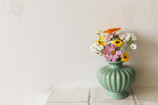 Elegante bouquet di fiori selvatici colorati su mensola piastrellata su sfondo muro rustico Bellissimi fiori estivi in vaso raccolti da composizioni floreali da giardino in camera moderna in casa
