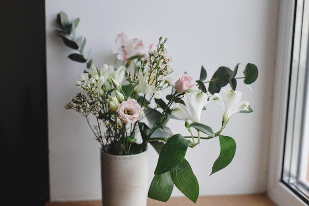 Elegante bouquet in vaso di ceramica alla finestra immagine lunatica Bellissimi fiori freschi da vicino