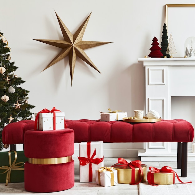 Elegante composizione natalizia all'interno del soggiorno con camino bianco, albero di Natale e corona, stelle, regali e decorazioni. Babbo Natale sta arrivando. Modello.