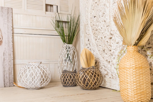 Elegante concetto di interni soggiorno con foglie essiccate in vaso cestini in rattan pianta parete in legno e