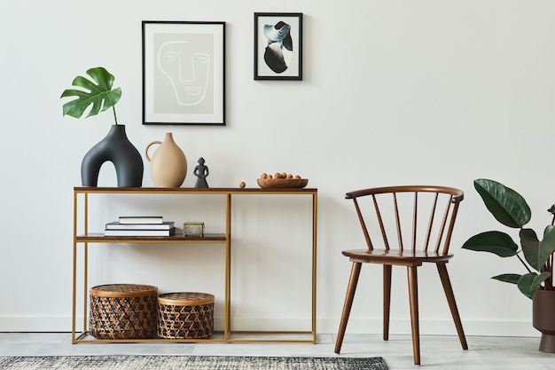 Elegante concetto di interno del soggiorno con cornici per poster, console in legno, sedia, foglia tropicale in vaso, cesti in rattan, piante, tappeti e accessori personali nell'arredamento della casa