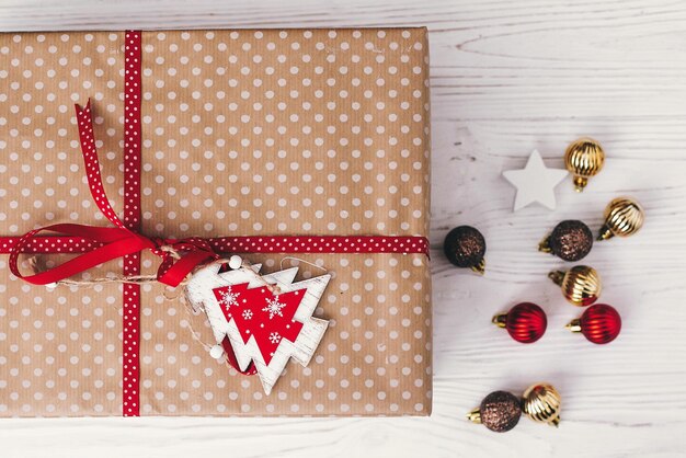 Elegante confezione regalo avvolta vista dall'alto con ornamenti e albero presente piatto laici saluti stagionali buone vacanze buon natale e felice anno nuovo concetto