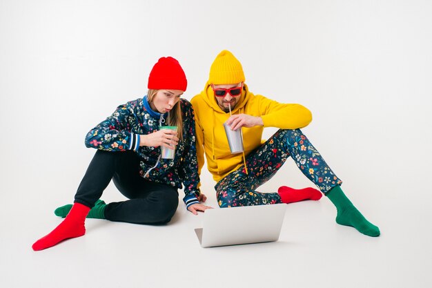 Elegante coppia di uomo e donna in abiti colorati guardando lo schermo del computer portatile