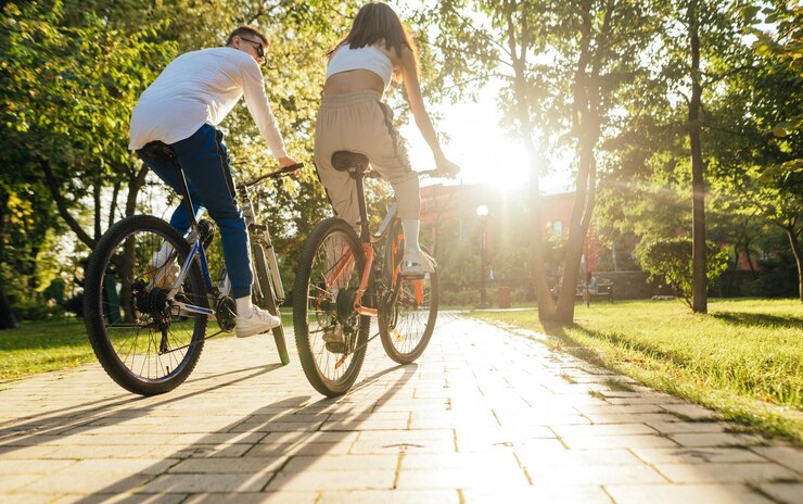 Elegante coppia in bicicletta nel parco autunnale al tramonto