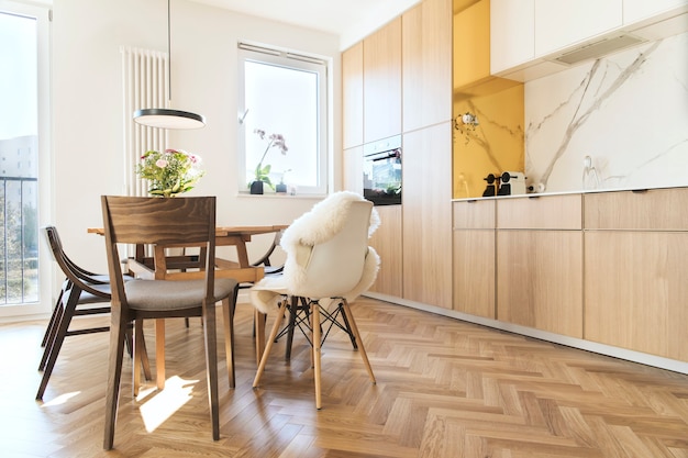 Elegante cucina scandinava e interno della sala da pranzo con tavolo, sedie e accessori della famiglia