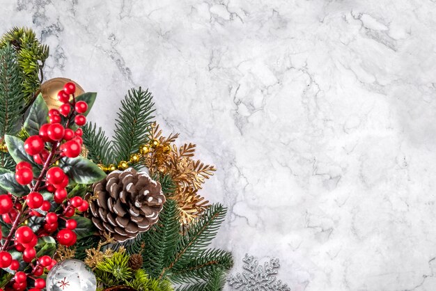 Elegante decoro natalizio su marmo bianco. Flatlay con copia spazio. Rami di abete rosso di Capodanno, coni, palline, decorazioni in oro. Sfondo di lusso per biglietti di auguri di design, poster, inviti a una festa