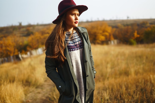 Elegante donna che indossa un cappotto nel parco in autunno