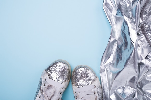 Elegante donna primavera o autunno argento scarpe e mantello su sfondo blu.