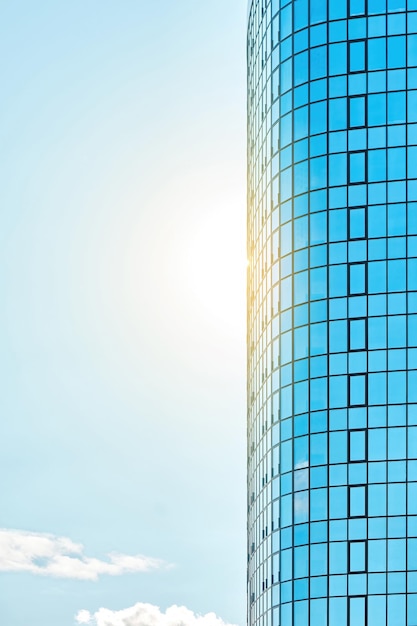 Elegante e alto edificio per uffici con facciata in vetro blu lucido che riflette la luce del sole