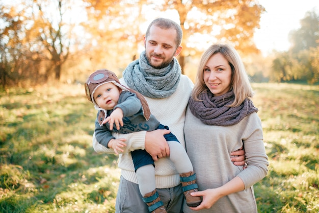 Elegante famiglia con il loro bambino piccolo nel parco d'autunno