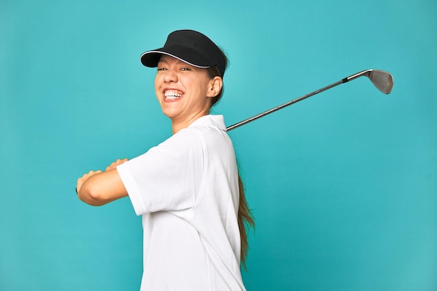 Elegante giovane donna che gioca a golf in studio