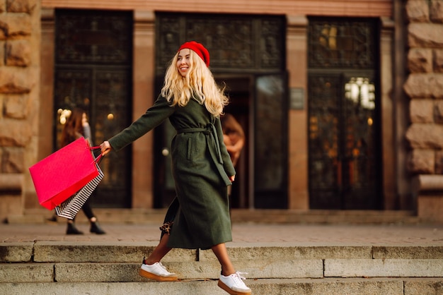 Elegante giovane donna in abiti alla moda con borse della spesa dopo lo shopping Acquisto autunnale