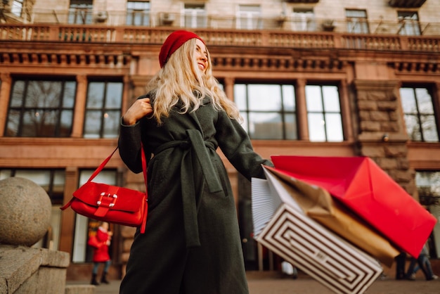 Elegante giovane donna in abiti alla moda con borse della spesa dopo lo shopping per lo shopping Venerdì nero