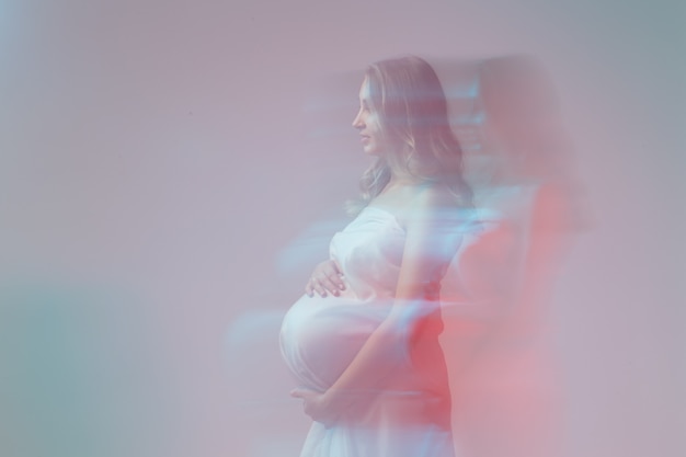 Elegante giovane donna incinta in piedi che indossa tessuto leggero fantasia gravidanza e concetto di fiaba