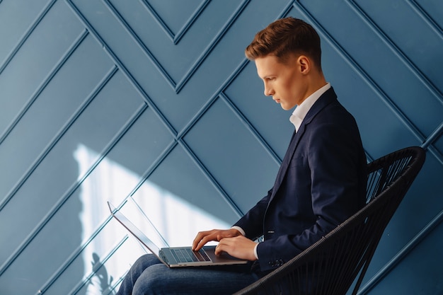 Elegante giovane ragazzo con laptop, giovane uomo d&#39;affari, lavoro libero professionista, sfondo aqua