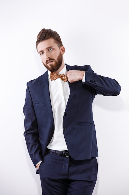 Elegante giovane uomo bello in costume classico nero ritratto in studio di moda