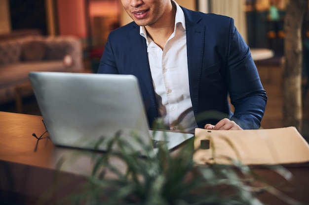 Elegante lavoratore remoto seduto davanti al suo computer