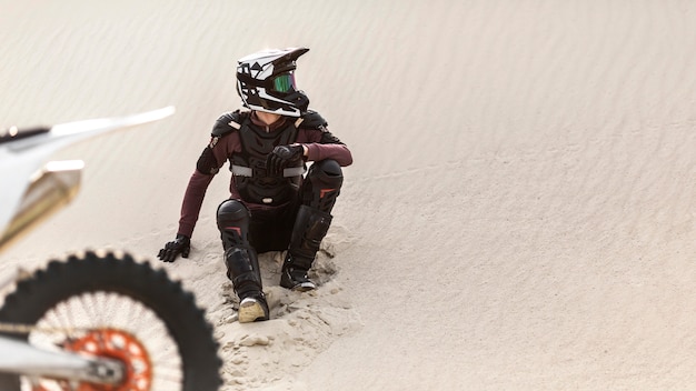 Elegante motociclista con moto nel deserto