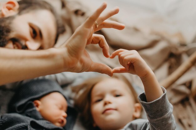 Elegante padre barbuto bacia una neonata addormentata Genitore che tiene in mano bambino a dondolo figlia figlio Autentico stile di vita genitoriale momento di paternità Papà vita familiare con 2 bambini