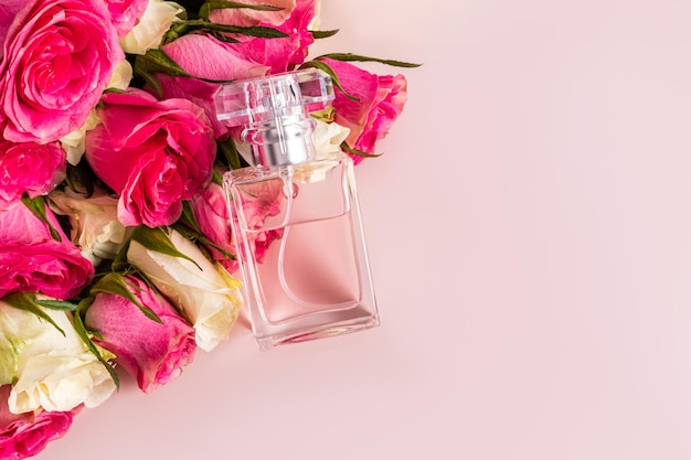Elegante profumo floreale in una bottiglia trasparente giace sui germogli di rose fresche Un spazio di copia Perfume e concetto di bellezza.