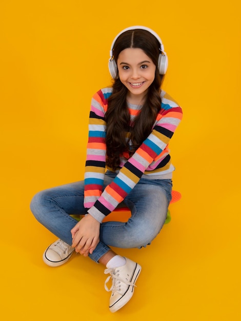 Elegante ragazza adolescente che ascolta la musica con le cuffie Concetto di stile di vita per bambini Auricolari wireless Stile urbano per bambini alla moda hipster teen