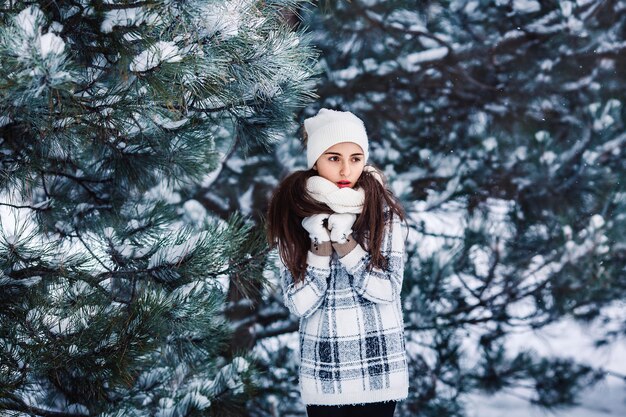 Elegante ragazza triste nella foresta invernale