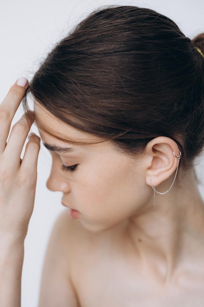 Elegante ritratto di una giovane ragazza modello di 15 anni con luce naturale in uno spazioso studio fotografico