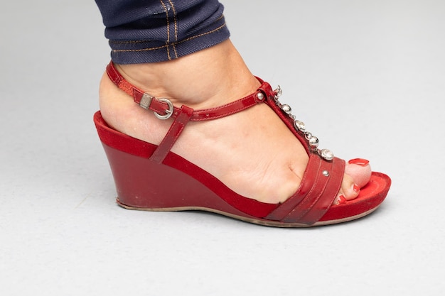 Elegante sandali a cuneo rosso su un piede da donna