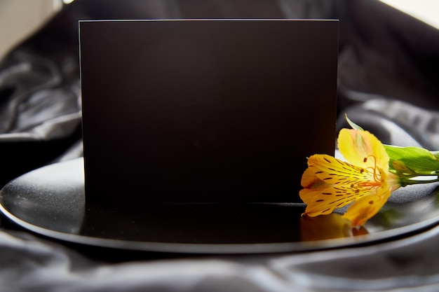 Elegante sfondo nero con fiore di alstroemeria Piastra nera con spazio per la copia della carta