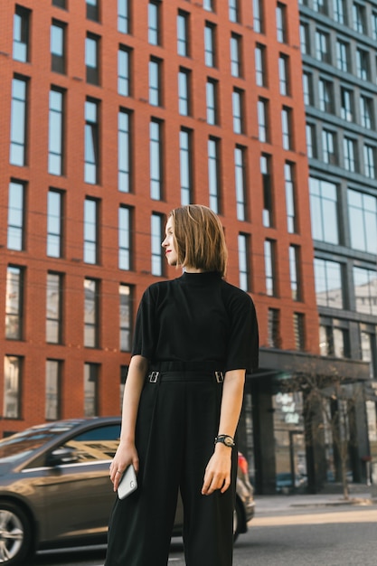 Elegante signora in abiti scuri si oppone all'architettura moderna