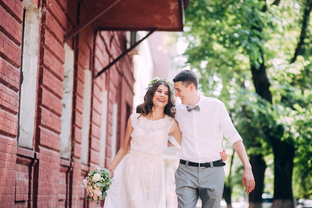 Elegante sposa e sposo che propongono insieme all'aperto in un giorno di nozze