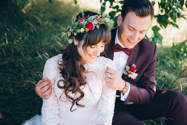 Elegante sposa e sposo che propongono insieme all'aperto in un giorno di nozze