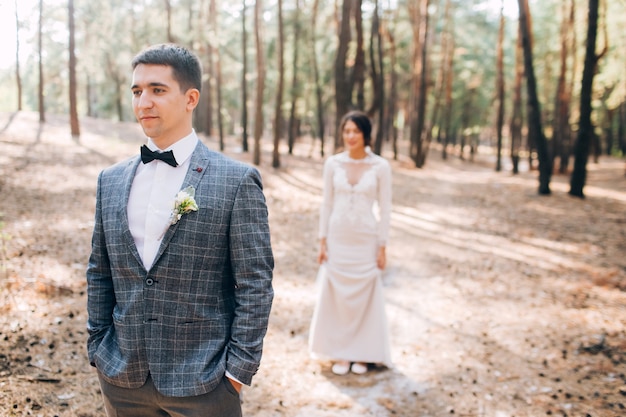 Elegante sposa e sposo che propongono insieme all'aperto in un giorno di nozze