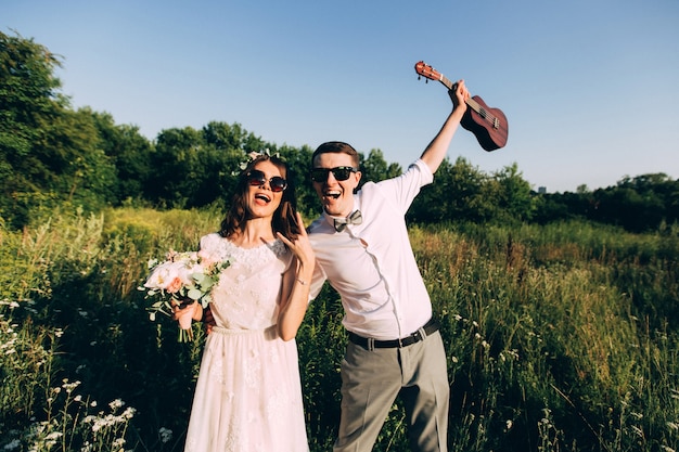 Elegante sposa e sposo che propongono insieme all'aperto in un giorno di nozze